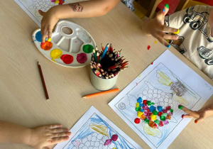 Dzieci malują kolorowe balony.