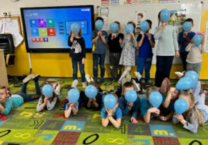 dzieci pozują z niebieskimi balonami