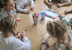 dzieci kolorują drewniane misie