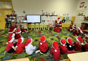 dzieci siedzą w kole z Mikołajem